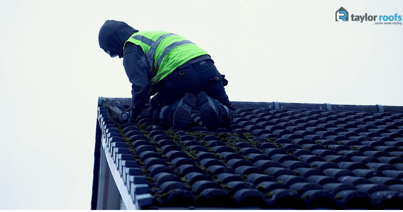 Roofer removing moss